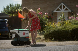 woman collecting parcel from DPD delivery robots