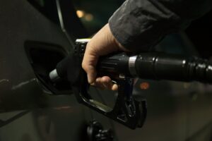 Hand on fuel hose filling up vehicle