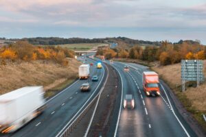 An image of a UK dual carriageway with HGV's travelling in both directions in autumn