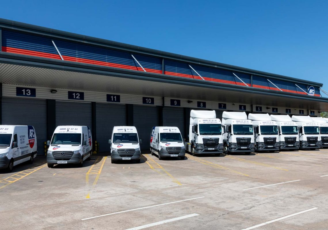 A photo of the Alternative Parcel Networks (APC) hub with vehicles lined up in size order from vans to trucks.